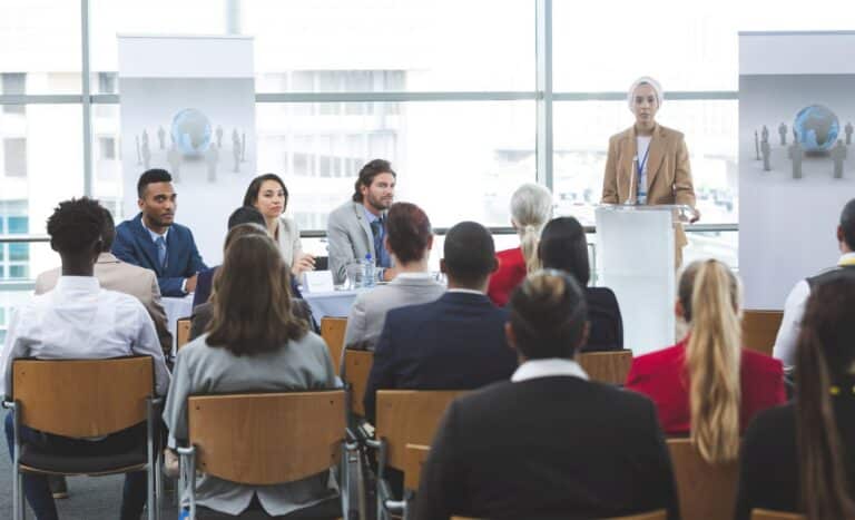 Front view of young mixed race female speaker speaking in a business seminar in modern office building